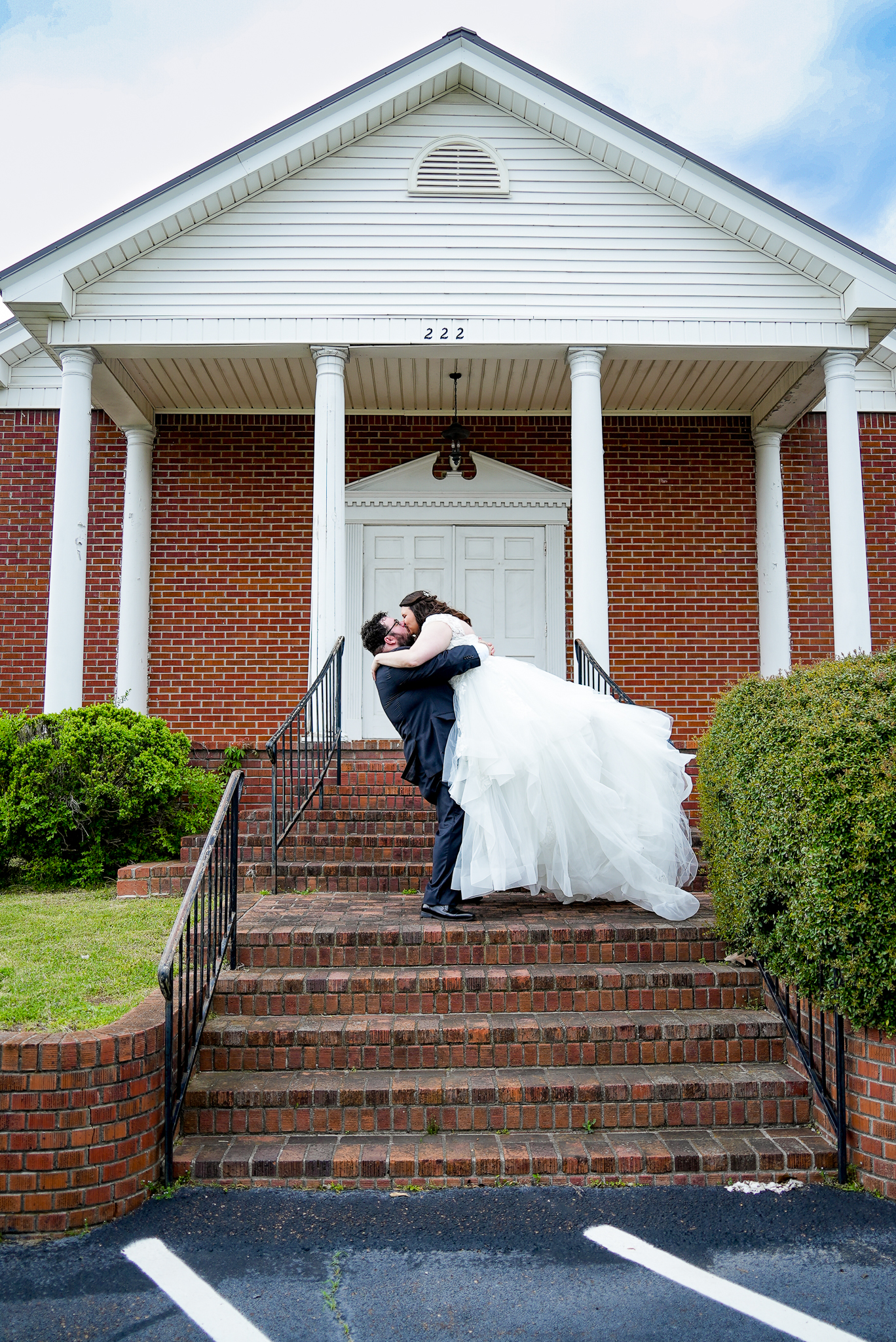Bride and groom kissing in front of the church before wedding